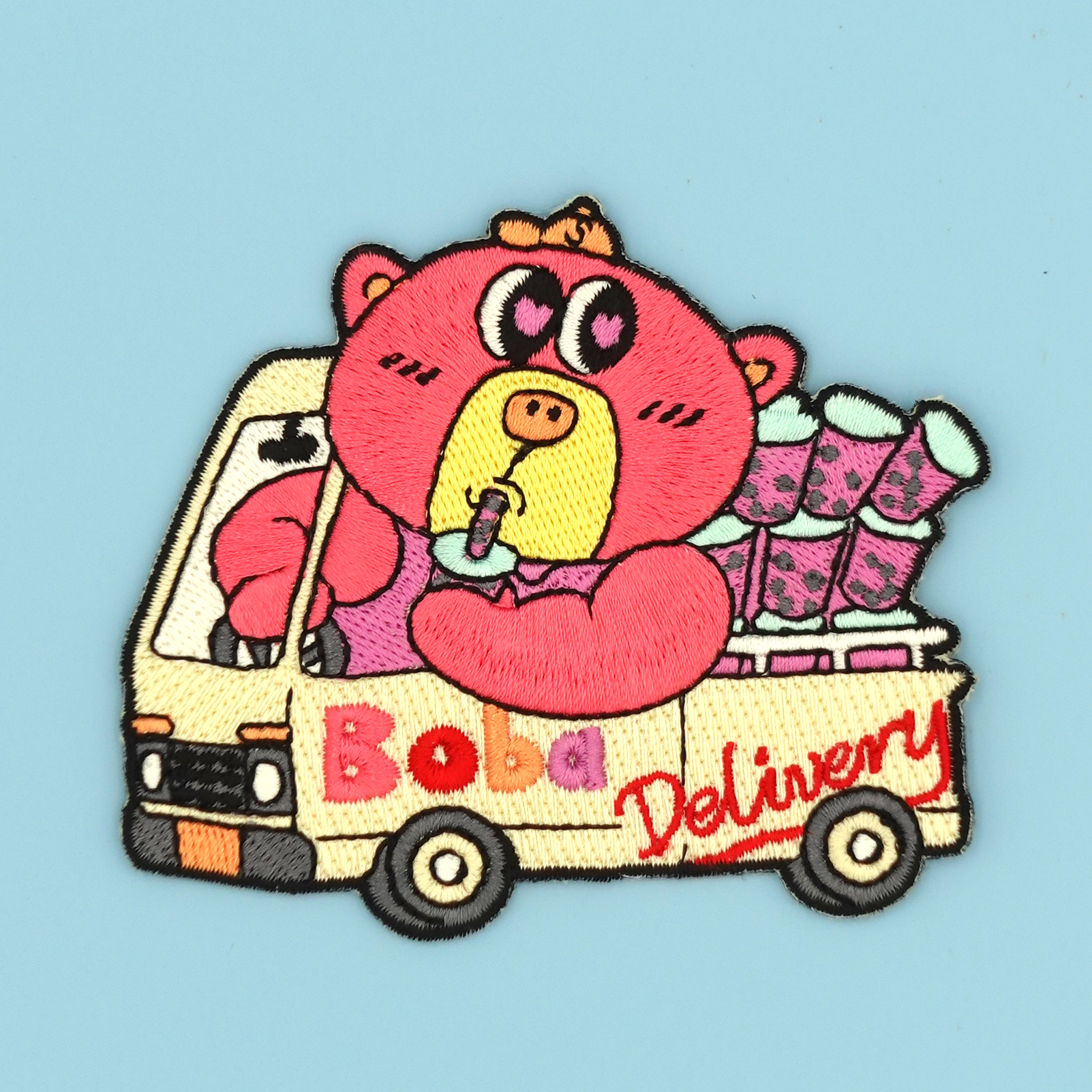 Embroidered Patch/Sticker of a cartoon bear character driving a 'Boba Delivery' truck on a blue background