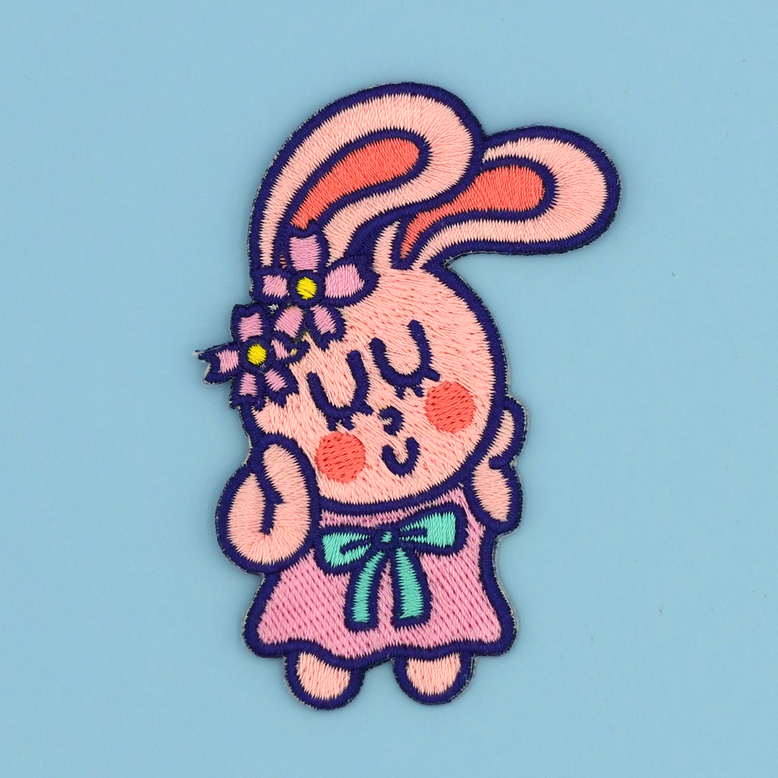 Embroidered patch/sticker of a cartoon bunny character with big ears on a blue background