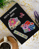 Journal with stickers on a journal book with flowers and a mug.