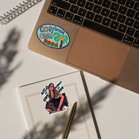 Sticker with 'California Chill' design on a laptop, with another sticker on a notebook.