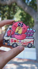 Video of Boba Delivery embroidered patch held in hand, showing size, texture, stitching details, and fabric under sunlight